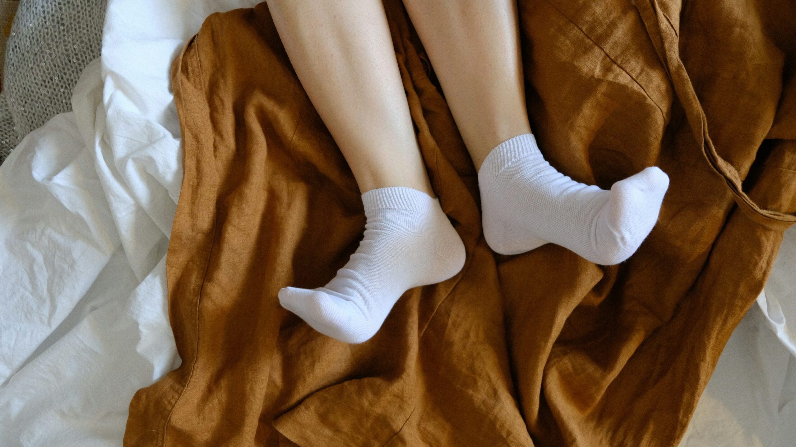 족저근막염 아침 통증, 첫걸음 디딜 때 이 스트레칭부터 하세요 6 침대 위에서 양말을 신은 발, 아침에 일어나 첫걸음을 딛기 전 상태를 표현한 이미지