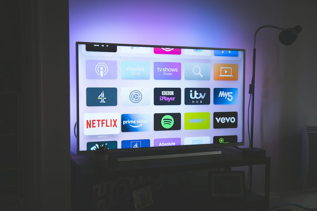 스마트TV 광고 끄는법, 삼성·LG 홈화면 설정으로 데이터까지 줄이기 7 어두운 방 안 TV 화면에 뜬 스트리밍 앱 아이콘 모음